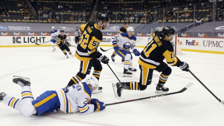 May 6, 2021; Pittsburgh, Pennsylvania, USA; Pittsburgh Penguins center Frederick Gaudreau (11) clears the puck against Buffalo Sabres center Arttu Ruotsalainen (25) during the second period at PPG Paints Arena. Mandatory Credit: Charles LeClaire-USA TODAY Sports