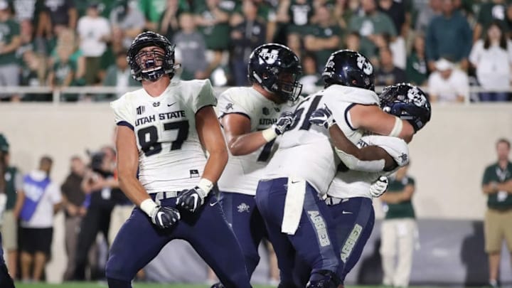 EAST LANSING, MI - AUGUST 31: Darwin Thompson #5 of the Utah State Aggies celebrate his fourth quarter touchdown with Dax Raymond #87 and Quin Ficklin #51 while playing the Michigan State Spartans at Spartan Stadium on August 31, 2018 in East Lansing, Michigan. Michigan State won the game 38-31. (Photo by Gregory Shamus/Getty Images) EAST LANSING, MI - AUGUST 31: Darwin Thompson #5 of the Utah State Aggies celebrate his fourth quarter touchdown with Dax Raymond #87 and Quin Ficklin #51 while playing the Michigan State Spartans at Spartan Stadium on August 31, 2018 in East Lansing, Michigan. Michigan State won the game 38-31. (Photo by Gregory Shamus/Getty Images)