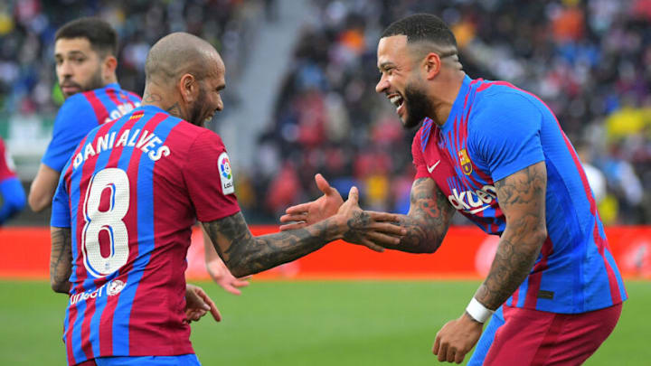 Memphis Depay (R) celebrates scoring his team's second goal with Dani Alves during the Spanish league football match between Elche CF and FC Barcelona at the Martinez Valero stadium in Elche on March 6, 2022. (Photo by JOSE JORDAN/AFP via Getty Images)