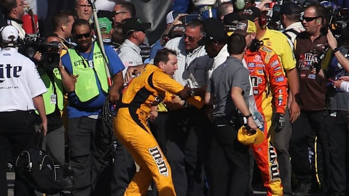 LAS VEGAS, NV - MARCH 12: Kyle Busch, driver of the #18 M&M's Toyota, is escorted away by a NASCAR official after an incident on pit road with Joey Logano (not pictured), driver of the #22 Pennzoil Ford, following the Monster Energy NASCAR Cup Series Kobalt 400 at Las Vegas Motor Speedway on March 12, 2017 in Las Vegas, Nevada. Busch and Logano made contact on the track during the last lap of the race leading to the incident on pit road. (Photo by Chris Graythen/Getty Images)