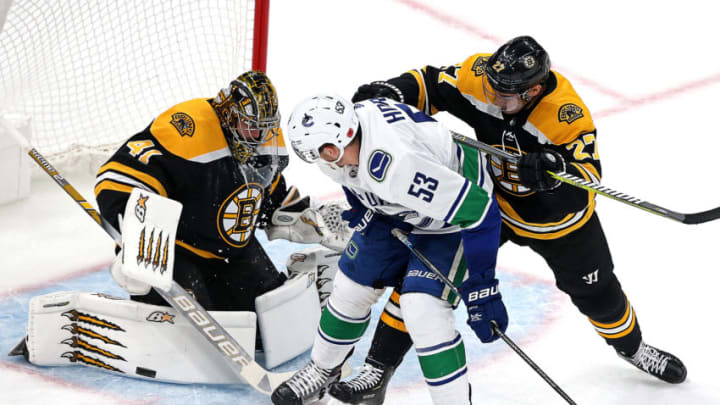 BOSTON - NOVEMBER 8: Boston Bruins goaltender Jaroslav Halak (41) makes a save as Boston Bruins defenseman John Moore (27) checks Vancouver Canucks center Bo Horvat (53) during the first period. The Boston Bruins host the Vancouver Canucks in a regular season NHL hockey game at TD Garden in Boston on Nov. 8, 2018. (Photo by Barry Chin/The Boston Globe via Getty Images)
