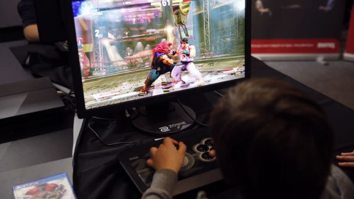 PARIS, FRANCE - FEBRUARY 18: A kid plays a video game "Street Fighter" developed by Capcom during an electronic video game tournament at the eSports World Convention (ESWC) on February 18, 2017 in Paris, France. The ESWC is the historic and emblematic event of electronic sports, bringing together every year since 2003 the best players in the world in video game tournaments designed as real live shows and broadcast live on the Internet or on television. 20 of the biggest American teams of Call of Duty will be present to compete in the tournament CWL Paris Open. Never had an event organized in Europe so much engaged the American eSport community. (Photo by Chesnot/Getty Images)