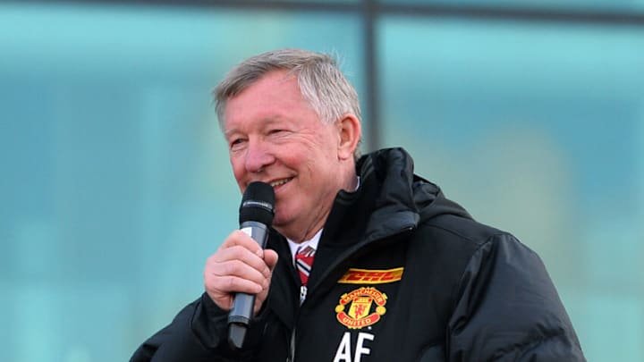 Retiring iconic Manchester United manager Alex Ferguson addresses the crowds from the champions' bus outside Old Trafford Stadium in Manchester, north west England, on May 13, 2013 as the team begins their parade to celebrate winning the Premier League title for the 13th time. AFP PHOTO/PAUL ELLIS (Photo credit should read PAUL ELLIS/AFP via Getty Images)