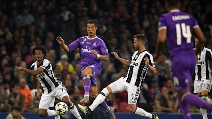 CARDIFF, WALES - JUNE 03: Cristiano Ronaldo of Real Madrid competes for the ball against Miralem Pjanic and Juan Cuadrado of Juventus during the UEFA Champions League final match between Juventus and Real Madrid at National Stadium of Wales on June 3, 2017 in Cardiff, Wales. (Photo by Etsuo Hara/Getty Images)