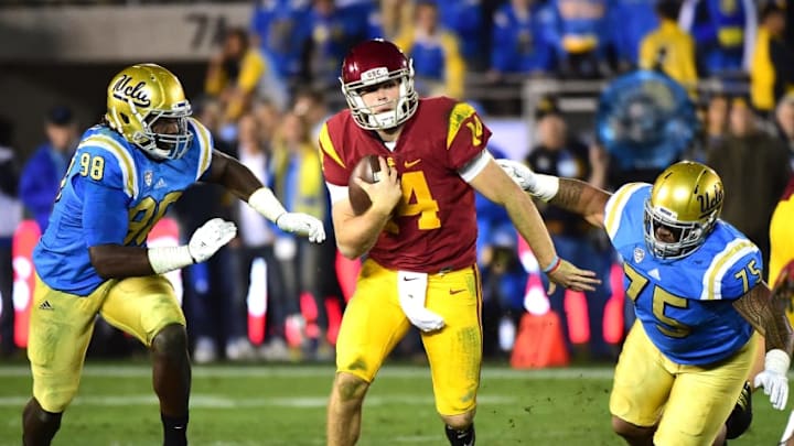 PASADENA, CA - NOVEMBER 19: Quarterback Sam Darnold #14 of the USC Trojans eludes the rush from defensive lineman Takkarist McKinley #98 and defensive lineman Boss Tagaloa #75 of the UCLA Bruins during a 36-14 Trojan win at Rose Bowl on November 19, 2016 in Pasadena, California. (Photo by Harry How/Getty Images)