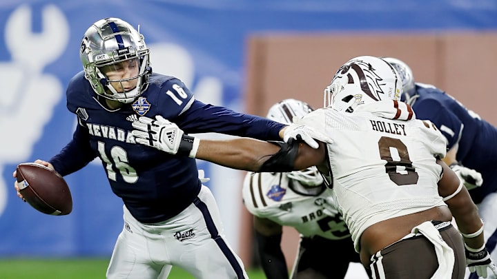 DETROIT, MICHIGAN – DECEMBER 27: Nate Cox #16 of the Nevada Wolf Pack tries to avoid being sacked by Ralph Holley #8 of the Western Michigan Broncos in the second half during the Quick Lane Bowl at Ford Field on December 27, 2021 in Detroit, Michigan. (Photo by Mike Mulholland/Getty Images)