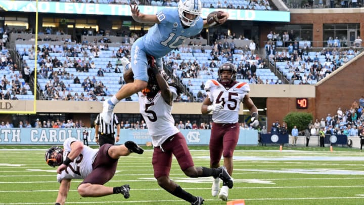 CHAPEL HILL, NORTH CAROLINA - OCTOBER 01: Drake Maye #10 of the North Carolina Tar Heels hurdles Nasir Peoples #5 of the Virginia Tech Hokies during the second half of their game at Kenan Memorial Stadium on October 01, 2022 in Chapel Hill, North Carolina. (Photo by Grant Halverson/Getty Images)