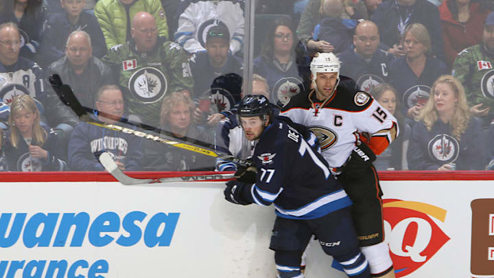 WINNIPEG, MB - MARCH 20: Chase De Leo #77 of the Winnipeg Jets and Ryan Getzlaf #15 of the Anaheim Ducks keep an eye on the play as they battle along the boards during third period action at the MTS Centre on March 20, 2016 in Winnipeg, Manitoba, Canada. (Photo by Jonathan Kozub/NHLI via Getty Images)