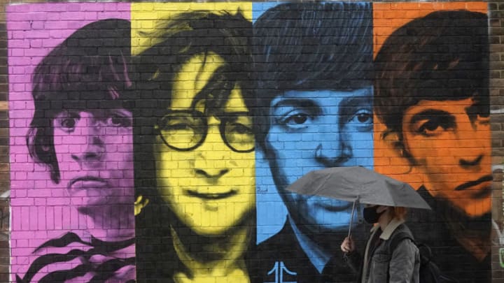 LIVERPOOL, ENGLAND - OCTOBER 12 A woman wears a Covid-19 protective face mask as she walks past a mural of the Beatles on October 12, 2020 in Liverpool, England. Under a new three-tier system, English cities will be subject to lockdown measures corresponding with the severity of covid-19 outbreaks in their areas. (Photo by Christopher Furlong/Getty Images) (Photo by Christopher Furlong/Getty Images)