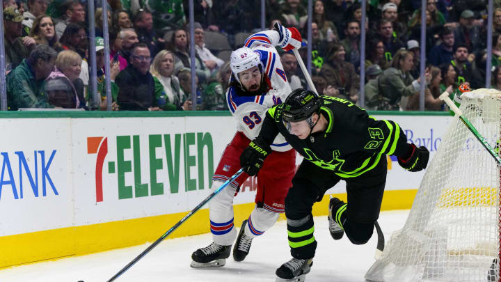 Mar 12, 2022; Dallas, Texas, USA; New York Rangers center Mika Zibanejad (93) and Dallas Stars defenseman Esa Lindell (23) chase the puck during the third period at the American Airlines Center. Mandatory Credit: Jerome Miron-USA TODAY Sports