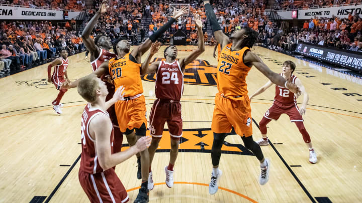Stillwater, Oklahoma, USA; Oklahoma State Cowboys forward Kalib Boone (22) shoots the ball while defended by Oklahoma Sooners guard Jamal Bieniemy (24) during the second half at Gallagher-Iba Arena. Mandatory Credit: Rob Ferguson-USA TODAY Sports