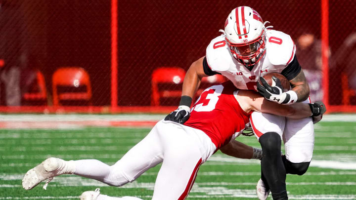 Nov 19, 2022; Lincoln, Nebraska, USA; Wisconsin Badgers running back Braelon Allen (0) is tackled by Nebraska Cornhuskers nickel back Isaac Gifford (23) during the fourth quarter at Memorial Stadium. Mandatory Credit: Dylan Widger-USA TODAY Sports