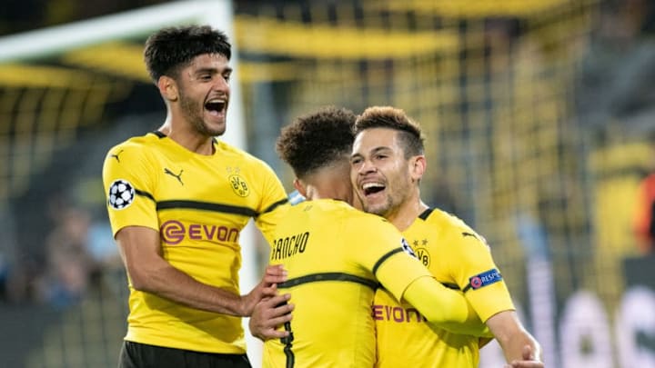 24 October 2018, North Rhine-Westphalia, Dortmund: Soccer: Champions League, Borussia Dortmund - Atlético Madrid, Group stage, Group A, Matchday 3: Dortmund's Raphael Guerreiro (r) rejoices with Jadon Sancho and Mahmoud Dahoud (l) over his 4-0 goal. Photo: Bernd Thissen/dpa (Photo by Bernd Thissen/picture alliance via Getty Images)