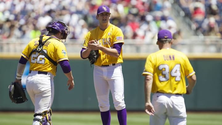 Jun 16, 2015; Omaha, NE, USA; LSU Tigers pitching coach Alan Dunn (34) walks to the mound to speak with pitcher Alex Lange (35) and catcher Kade Scivicque (22) against the Cal State Fullerton Titans during the first inning in the 2015 College World Series at TD Ameritrade Park. Mandatory Credit: Bruce Thorson-USA TODAY Sports