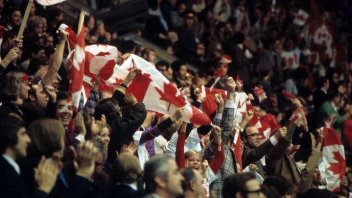 MOSCOW - SEPTEMBER 24, 1972: Some of the 3,000 Canadian fans cheer and wave the Canadian flag during the game between Canada and the Soviet Union in Game 6 of the 1972 Summit Series on September 24, 1972 at the Luzhniki Ice Palace in Moscow, Russia. (Photo by Melchior DiGiacomo/Getty Images)