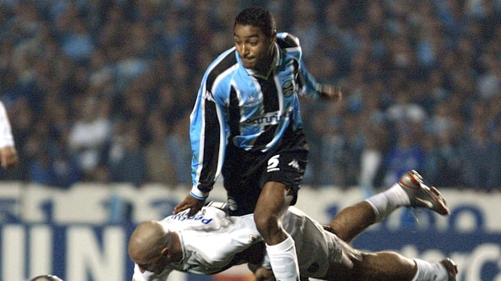 Roger Marques (C), of team Gremio leaps over Danie