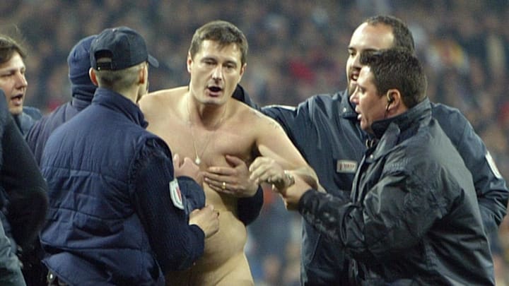 Security men hold a streaker during thei