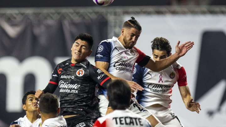 Jugadores de Xolos de Tijuana y Chivas del Guadalajara pelean un balón por los aires. Jugadores de Xolos de Tijuana y Chivas del Guadalajara pelean un balón por los aires.