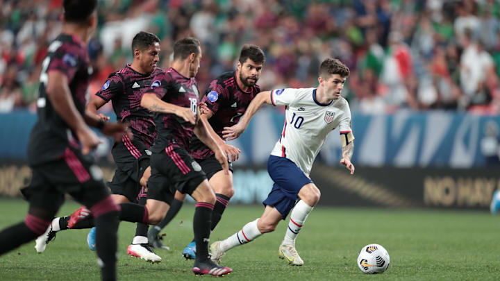 Pulisic controla un balón ante la marca de jugadores mexicanos.