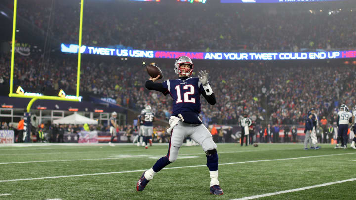 Tom Brady warms up on the sideline on Wild Card Weekend