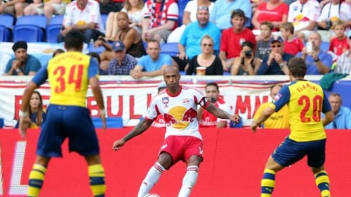 Jul 26, 2014; Harrison, NJ, USA; New York Red Bulls forward Thierry Henry (14) controls the ball against Arsenal midfielder Francis Coquelin (34) and Arsenal midfielder Mathieu Flamini (20) during the second half of a game at Red Bull Arena. The Red Bulls defeated Arsenal 1-0. Mandatory Credit: Brad Penner-USA TODAY Sports