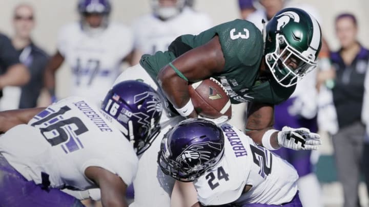 EAST LANSING, MI - OCTOBER 15: Runningback LJ Scott #3 of the Michigan State Spartans is upended by cornerback Montre Hartage #24 of the Northwestern Wildcats as safety Godwin Igwebuike #16 of the Northwestern Wildcats enters the play during the first half at Spartan Stadium on October 15, 2016 in East Lansing, Michigan. Northwestern defeated Michigan State 54-40. (Photo by Duane Burleson/Getty Images)