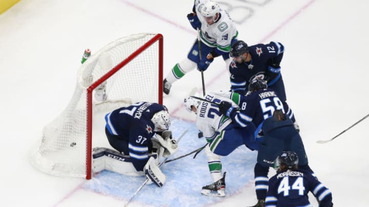 EDMONTON, ALBERTA - JULY 29: Antoine Roussel #26 of the Vancouver Canucks scores a third period goal against Connor Hellebuyck #37 of the Winnipeg Jets in an exhibition game prior to the 2020 NHL Stanley Cup Playoffs at Rogers Place on July 29, 2020 in Edmonton, Alberta. (Photo by Jeff Vinnick/Getty Images)