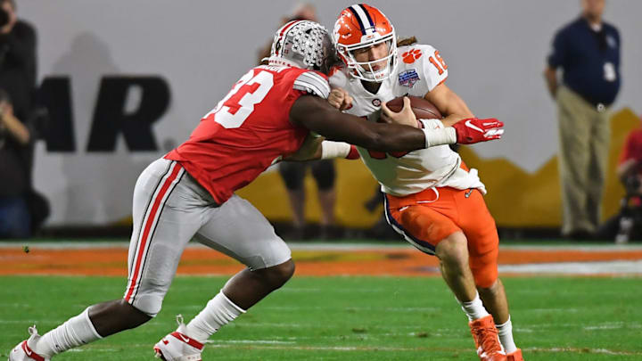 GLENDALE, ARIZONA – DECEMBER 28: Trevor Lawrence #16 of the Clemson Tigers is wrapped up by Zach Harrison #33 of the Ohio State Buckeyes in the first half during the College Football Playoff Semifinal at the PlayStation Fiesta Bowl at State Farm Stadium on December 28, 2019 in Glendale, Arizona. (Photo by Norm Hall/Getty Images)