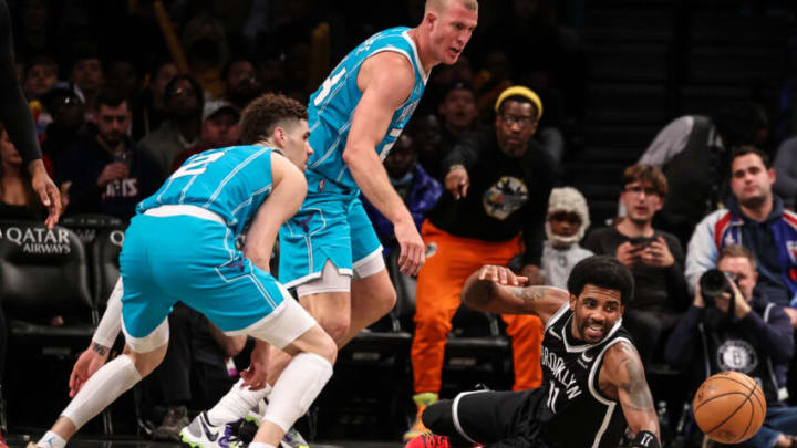 Mar 27, 2022; Brooklyn, New York, USA; Brooklyn Nets guard Kyrie Irving (11) reaches for a loose ball against Charlotte Hornets guard LaMelo Ball (2) and Charlotte Hornets center Mason Plumlee (24) during the second half at Barclays Center. Mandatory Credit: Vincent Carchietta-USA TODAY Sports