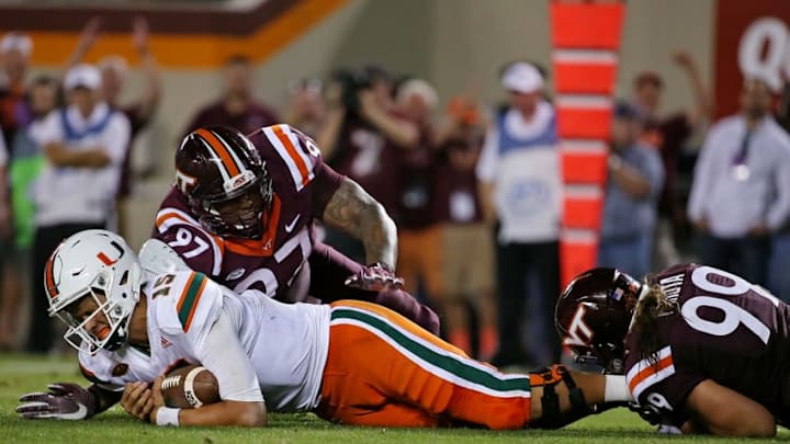 Oct 20, 2016; Blacksburg, VA, USA; Miami Hurricanes quarterback Brad Kaaya (15) is sacked by Virginia Tech Hokies defensive lineman Vinny Mihota (99) and defensive tackle Tim Settle (97) during the fourth quarter at Lane Stadium. Mandatory Credit: Peter Casey-USA TODAY Sports