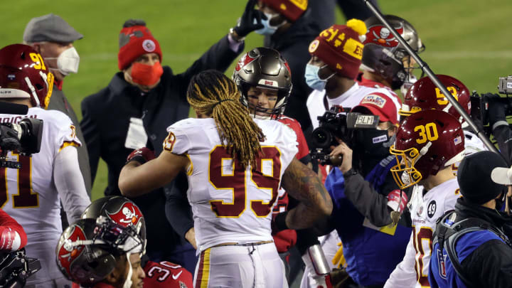 LANDOVER, MARYLAND – JANUARY 09: Defensive end Chase Young #99 of the Washington Football Team congratulates quarterback Tom Brady #12 of the Tampa Bay Buccaneers after the Buccaneers defeated the Washington Football Team to win the playoff game at FedExField on January 09, 2021 in Landover, Maryland. (Photo by Rob Carr/Getty Images)