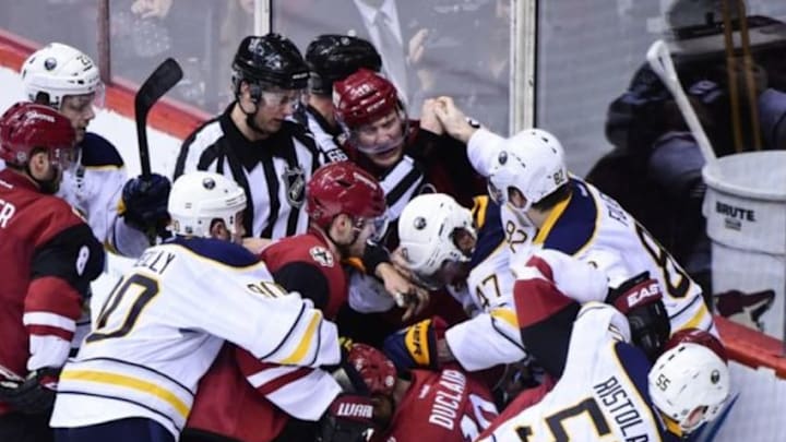 Jan 18, 2016; Glendale, AZ, USA; Arizona Coyotes left wing Anthony Duclair (10) and right wing Shane Doan (19) and left wing Mikkel Boedker (89) fight with Buffalo Sabres defenseman Zach Bogosian (47), and left wing Marcus Foligno (82) and defenseman Rasmus Ristolainen (55) as NHL linesman Darren Gibbs (66) tries to break them up after the conc;usion of the game at Gila River Arena. Mandatory Credit: Matt Kartozian-USA TODAY Sports