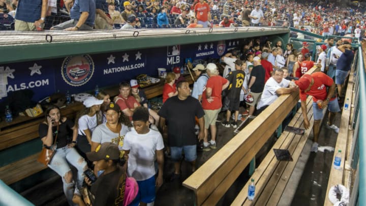 Jul 17, 2021; Washington, District of Columbia, USA; Fans take cover in the San Diego Padres dugout after apparent gun shots were heard during the game between the Washington Nationals and the San Diego Padres at Nationals Park. Mandatory Credit: Brad Mills-USA TODAY Sports