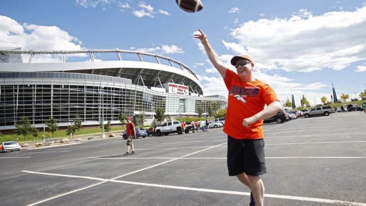 Sep 7, 2014; Denver, CO, USA; Fan Greg Ahern tosses a football at a tailgate party outside the stadium before the game between the Denver Broncos and the Indianapolis Colts at Sports Authority Field at Mile High. Mandatory Credit: Chris Humphreys-USA TODAY Sports