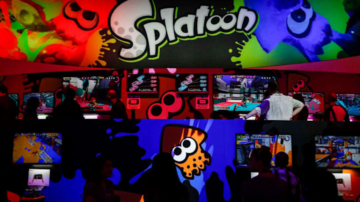 Attendees play Nintendo Co.'s Splatoon game during the E3 Electronic Entertainment Expo in Los Angeles, California, U.S., on Tuesday, June 10, 2014. Nintendo, threatened with becoming an also-ran in the market for home consoles, announced a half-dozen new titles for the Wii U in an online presentation for the annual Electronic Entertainment Expo, including a multiplayer shooter game called Splatoon and Super Smash Bros., and unveiled a collectible-toy platform for the console called Amiibo, similar to Activision Blizzard Inc.s Skylanders. Photographer: Patrick T. Fallon/Bloomberg via Getty Images