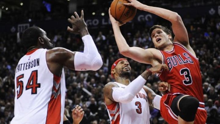 Nov 13, 2014; Toronto, Ontario, CAN; Chicago Bulls forward Doug McDermott (3) takes a shot as Toronto Raptors forward Patrick Patterson (54) and forward James Johnson (3) defend during the second quarter at Air Canada Centre. Mandatory Credit: Peter Llewellyn-USA TODAY Sports