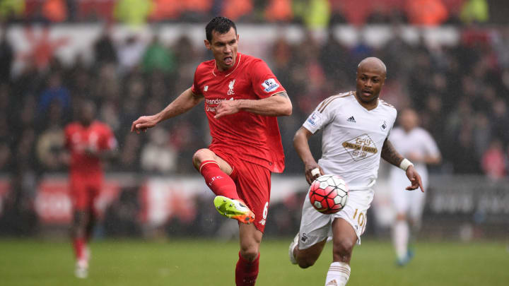 SWANSEA, WALES – MAY 01: Dejan Lovren of Liverpool clears the ball from Andre Ayew of Swansea City during the Barclays Premier League match between Swansea City and Liverpool at The Liberty Stadium on May 1, 2016 in Swansea, Wales. (Photo by Stu Forster/Getty Images)