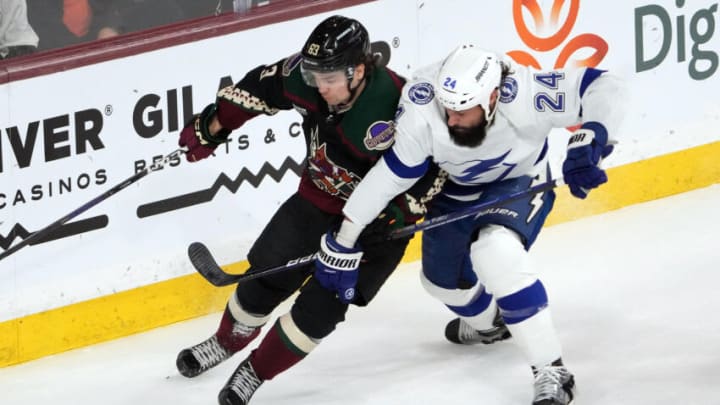 Feb 15, 2023; Tempe, Arizona, USA; Arizona Coyotes left wing Matias Maccelli (63) and Tampa Bay Lightning defenseman Zach Bogosian (24) battle for position during the second period at Mullett Arena. Mandatory Credit: Joe Camporeale-USA TODAY Sports