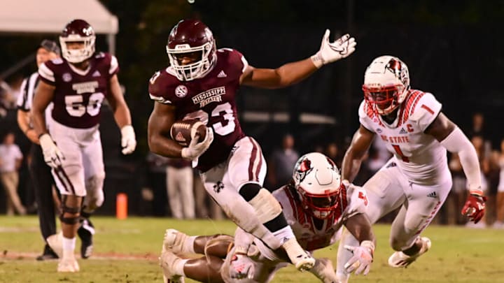 Sep 11, 2021; Starkville, Mississippi, USA;Mississippi State Bulldogs running back Dillon Johnson (23) runs the ball while defended by North Carolina State Wolfpack defensive tackle C.J. Clark (5) and linebacker Isaiah Moore (1) during the fourth quarter at Davis Wade Stadium at Scott Field. Mandatory Credit: Matt Bush-USA TODAY Sports