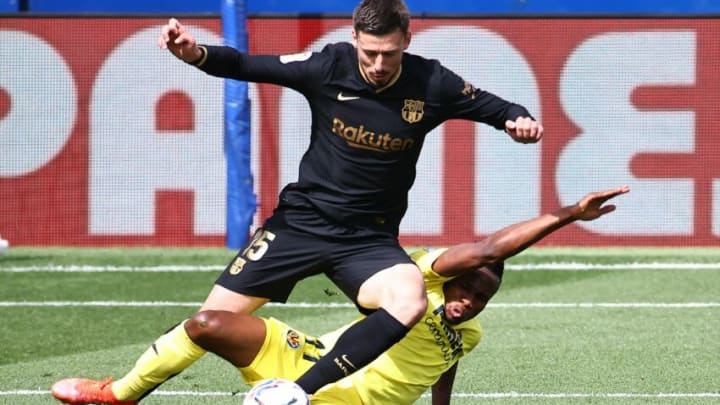 Barcelona's French defender Clement Lenglet (L) challenges Villarreal's Nigerian midfielder Samuel Chukwueze during the Spanish League football match between Villarreal CF and FC Barcelona at La Ceramica stadium in Vila-real on April 25, 2021. (Photo by JOSE JORDAN / AFP) (Photo by JOSE JORDAN/AFP via Getty Images)