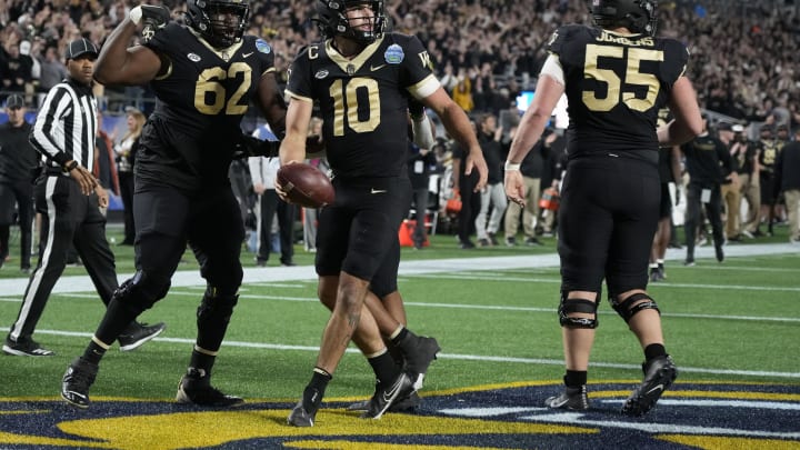 Dec 4, 2021; Charlotte, NC, USA; Wake Forest Demon Deacons quarterback Sam Hartman (10) celebrates with teammates after scoring a touchdown against the Pittsburgh Panthers during the first quarter in the ACC championship game at Bank of America Stadium. Mandatory Credit: Jim Dedmon-USA TODAY Sports