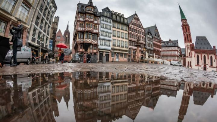 Buildings at the Roemerberg square in Frankfurt am Main, western Germany, reflect in a puddle on November 13, 2018. (Photo by Frank Rumpenhorst / dpa / AFP) / Germany OUT (Photo credit should read FRANK RUMPENHORST/DPA/AFP via Getty Images)