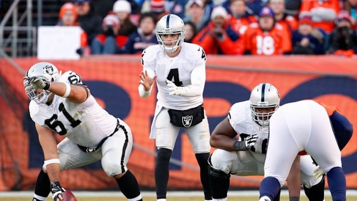 Dec 28, 2014; Denver, CO, USA; Oakland Raiders center Stefen Wisniewski (61) and quarterback Derek Carr (4) in the second quarter against the Denver Broncos at Sports Authority Field at Mile High. The Broncos defeated the Raiders 47-14. Mandatory Credit: Isaiah J. Downing-USA TODAY Sports