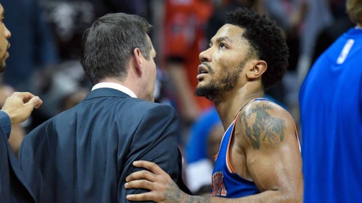 Dec 28, 2016; Atlanta, GA, USA; New York Knicks head coach Jeff Hornacek (left) is restrained by guard Derrick Rose (25) after reacting to a call during the game against the Atlanta Hawks during the overtime at Philips Arena. The Hawks defeated the Knicks 102-98 in overtime. Mandatory Credit: Dale Zanine-USA TODAY Sports