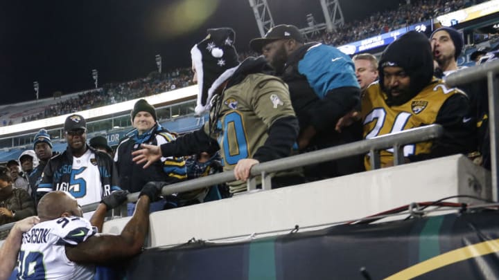 JACKSONVILLE, FL - DECEMBER 10: Defensive End Quinton Jefferson # 99 of the Seattle Seahawks tries to climb up in the stands to confronted a group of Jaguars fans after he was nearly hit by flying objects thrown at him. Jefferson had to be restrained by Seahawks staff and ushered into the locker room in the last few seconds of the game against the Jacksonville Jaguars at EverBank Field on December 10, 2017 in Jacksonville, Florida. The Jaguars defeated the Seahawks 30 to 24. (Photo by Don Juan Moore/Getty Images)