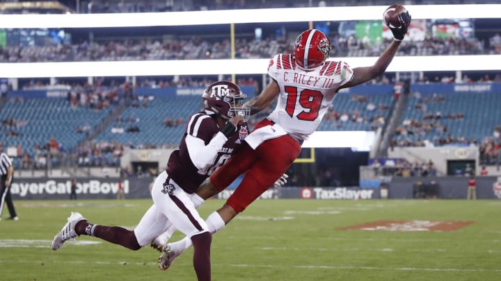 JACKSONVILLE, FL – DECEMBER 31: C.J. Riley III #19 of the North Carolina State Wolfpack makes a nine-yard touchdown reception against Myles Jones #10 of the Texas A&M Aggies in the second quarter of the TaxSlayer Gator Bowl at TIAA Bank Field on December 31, 2018 in Jacksonville, Florida. (Photo by Joe Robbins/Getty Images)
