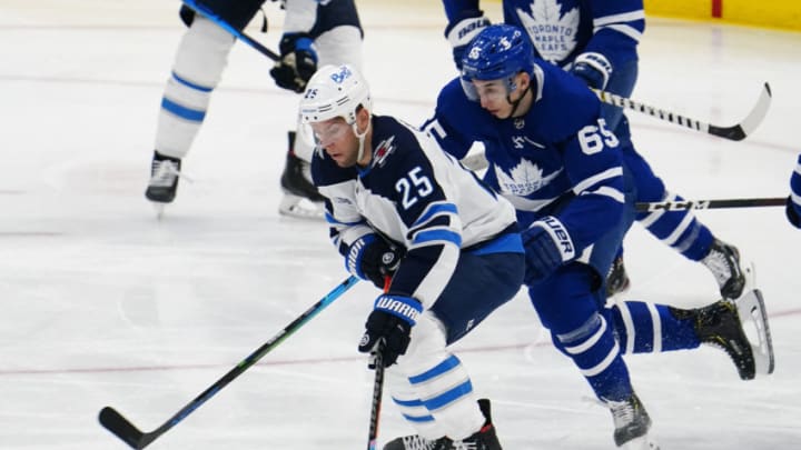 Apr 15, 2021; Toronto, Ontario, CAN; Winnipeg Jets forward Paul Stastny (25) tries to skate around Toronto Maple Leafs forward Ilya Mikheyev (65) during the first period at Scotiabank Arena. Mandatory Credit: John E. Sokolowski-USA TODAY Sports