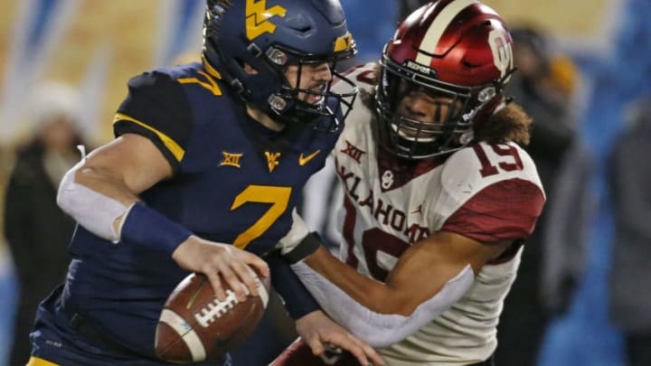 MORGANTOWN, WV - NOVEMBER 23: Caleb Kelly #19 of the Oklahoma Sooners forces Will Grier #7 of the West Virginia Mountaineers to fumble the football on November 23, 2018 at Mountaineer Field in Morgantown, West Virginia. (Photo by Justin K. Aller/Getty Images)