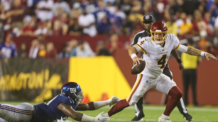 LANDOVER, MARYLAND – SEPTEMBER 16: Taylor Heinicke #4 of the Washington Football Team rushes from Leonard Williams #99 of the New York Giants during the third quarter at FedExField on September 16, 2021 in Landover, Maryland. (Photo by Rob Carr/Getty Images)