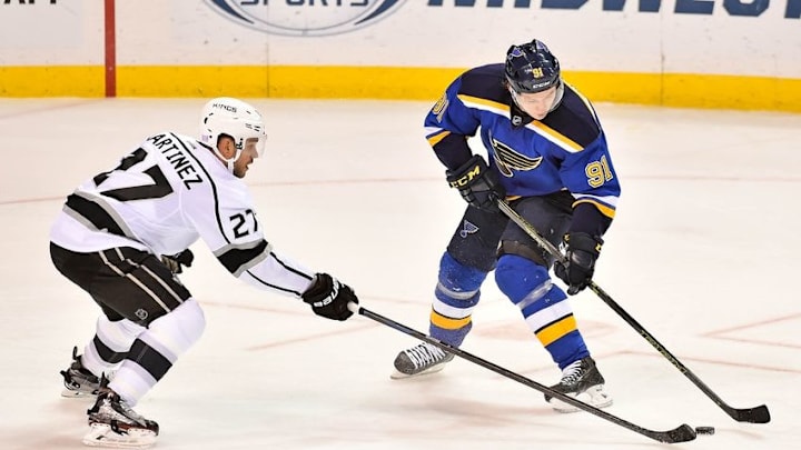 Nov 3, 2015; St. Louis, MO, USA; Los Angeles Kings defenseman Alec Martinez (27) reaches for the puck on St. Louis Blues right wing Vladimir Tarasenko (91) during the third period at Scottrade Center. The Los Angeles Kings defeat the St. Louis Blues 3-0. Mandatory Credit: Jasen Vinlove-USA TODAY Sports